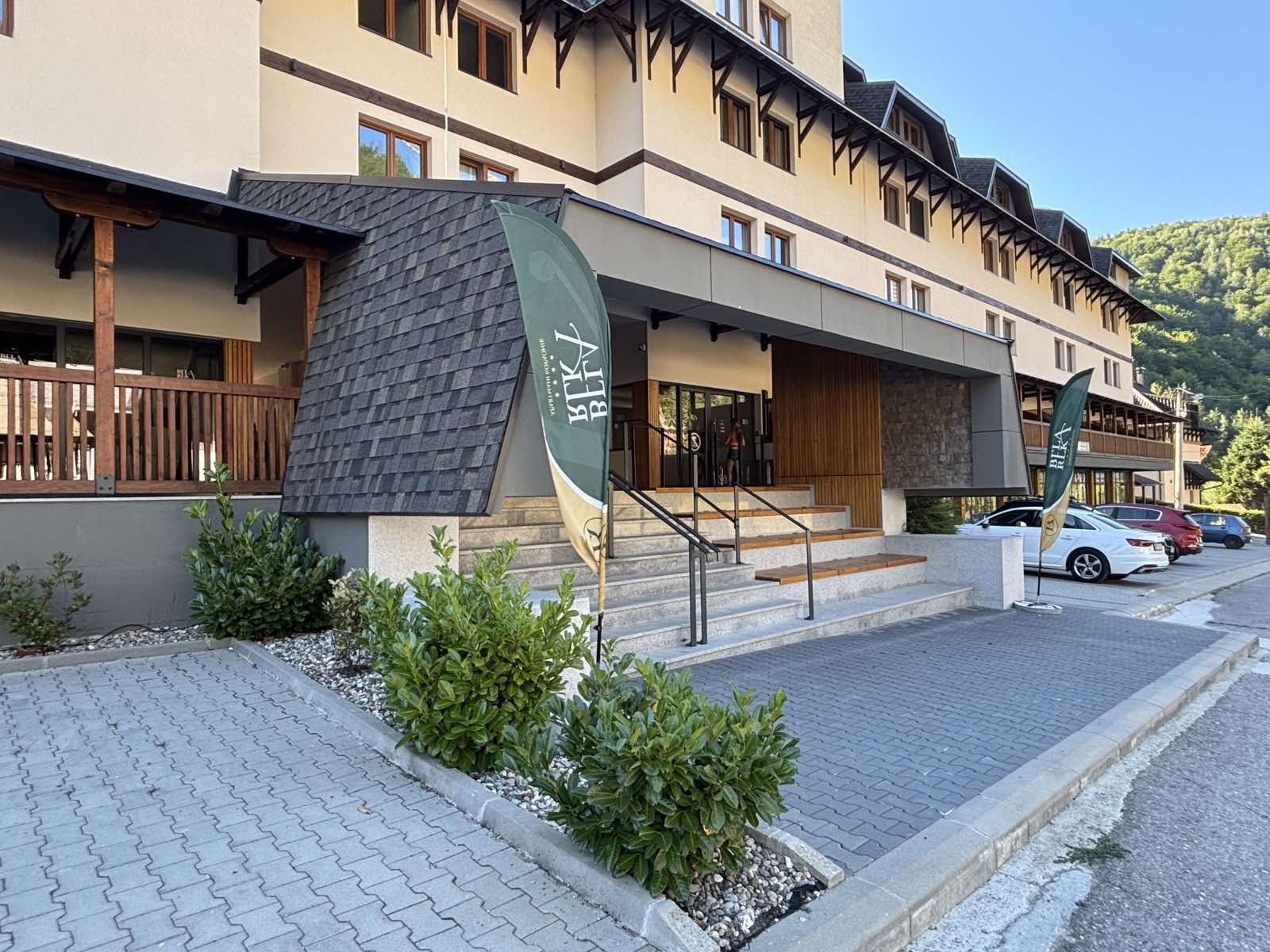 Main entrance to the apartment building in Brzeće, with steps and parking